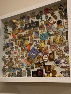 a display case filled with lots of different types of pins and badges on the wall