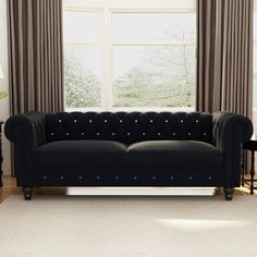 a black couch sitting in front of a window