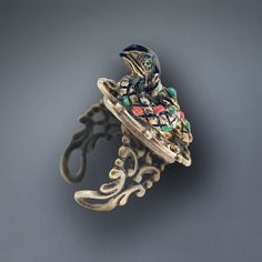 Our snake ring is in the form of a royal serpent with crystal eyes, a neck band of tiny crystal and a body detailed in enamel. Three dimensional, he rests gracefully upon an adjustable, comfortable ring band that fits sizes 6-9. Choice of bronze or silver finish. Shakespeare wrote "Be the innocent flower...be the serpent under it!" Produced in our Los Angeles studio. The snake has been a powerful symbol from the beginning of human history. The serpent goddess Wadjet was an early Egyptian deity. In the Garden of Eden, it is the serpent who creates the drama. The snake's dual symbolism of good and evil has been expressed through all cultures. The very first engagement ring ever presented was to Queen Victoria from Prince Albert. It was a snake, signifying eternal love and wisdom and the betr Spiritual Snake-shaped Metal Jewelry, Spiritual Metal Jewelry In Snake Shape, Ceremonial Adjustable Ring Jewelry, Adjustable Snake-shaped Metal Jewelry, Adjustable Snake Shaped Metal Jewelry, Unique Snake-shaped Metal Jewelry, Adjustable Metal Snake Ring, Unique Metal Jewelry With Snake Shape, Elegant Adjustable Metal Snake Ring