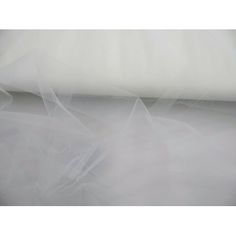 a roll of white sheer fabric on top of a bed