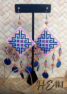 a pair of earrings with beads hanging from it