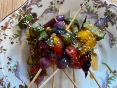 several skewers of vegetables are on a plate