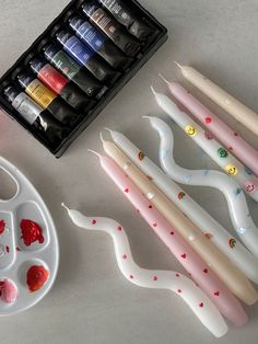 some paint brushes are sitting on a table next to an empty tray with other paints