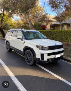 a white suv is parked on the side of the road