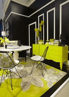 a black and white room with yellow accents on the walls, tables and chairs in front of them