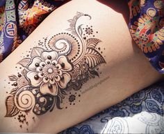 a woman's leg with a henna tattoo on it