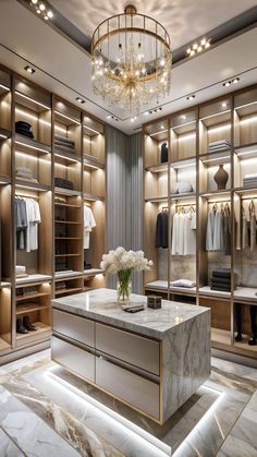 an elegant walk in closet with marble counter tops and gold cabinets, chandelier and lighting