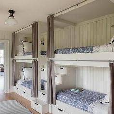 bunk beds are lined up against the wall in this room with white walls and wood flooring