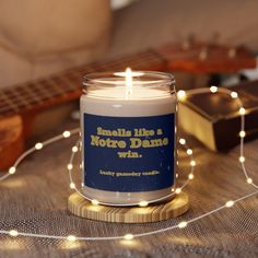 a candle sitting on top of a table next to a string of lights and a guitar