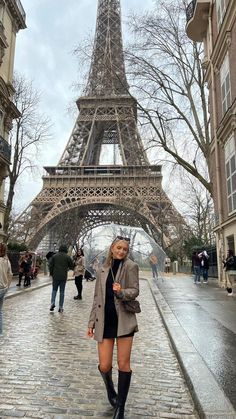 a woman standing in front of the eiffel tower