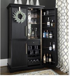 a black cabinet filled with liquor bottles and glasses