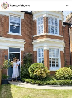 two women standing in front of a house