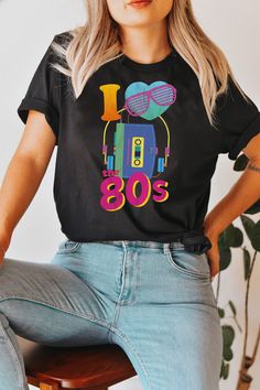 80s t shirts 80's shirt 80s shirt 80s t shirt 80s nostalgia 80's shirts 80s rock t shirts 80s movie shirts 80s shirt women 80s kids shirt This 80's shirt will take you back in time. Is retro and vintage, perfect for you to party like its the 80's! This fun pop culture t-shirt would be a great gift for women, men, or children as a birthday gift, anniversary gift, Thanksgiving gift, and graduation gifts! The perfect funky shirt for your next 80s party! Show your Eighties Love of cassette mixtapes, cassettes mullet haircuts, and leg warmers! The perfect neon colors as 80s costume, 80s clothing for men, 80s clothing for women. The perfect old-school gift for special occasions.  Unisex fit. Please refer to the size chart in the last image of the listing.   This t-shirt is everything you've drea Trendy Music Festival Fan Merchandise Tops, Trendy Tops For Music Festivals Fan Merchandise, Trendy Fan Merchandise Tops For Music Festivals, Retro Printed Tops For Music Festivals, 90s Inspired Black Top With Sublimation Print, 90s Inspired Fan Merchandise T-shirt For Summer, 90s Inspired T-shirt For Summer Fan Merchandise, Retro Relaxed Fit Tops For Music Festivals, Retro Graphic Tops For Music Festivals