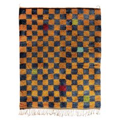 an orange, blue and black checkered rug with fringes on the bottom corner