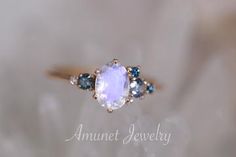 a close up view of an amethyst jewelry ring with blue and white stones