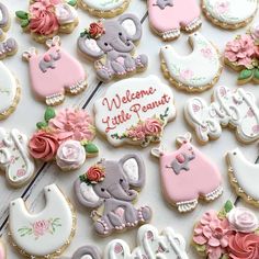 baby shower cookies decorated with pink and gray icing are displayed on a white surface