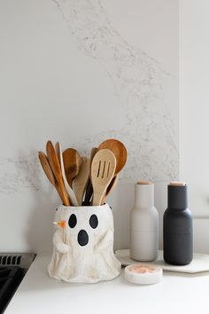 kitchen utensils and spoons in a cup on the counter