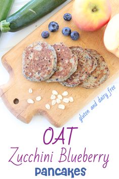 an image of food on a cutting board with the title oat zucchini blueberry pancakes