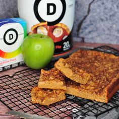 two pieces of cake sitting on top of a cooling rack next to an apple