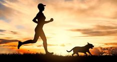 a person running with a dog at sunset