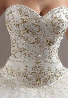 a white and gold wedding dress is shown