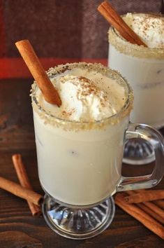 two mugs filled with cinnamon and whipped cream