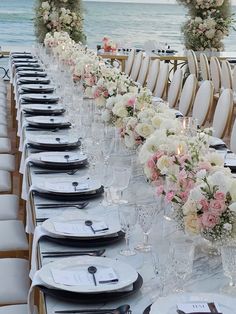 a long table set up with white and pink flowers