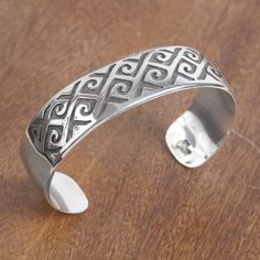 Designed by Maria Belen Nilson this cuff bracelet from Mexico will add the beauty of Taxco handicrafts to your wardrobe. The bracelet is handcrafted of high-polish sterling silver accentuated by curling patterns at the front. The patterns are detailed with a darkly oxidized finish. Artisan Sterling Silver Bangle As Gift, Handmade Sterling Silver Cuff Bracelet Bangle, Adjustable Artisan Sterling Silver Bangle Bracelet, Stamped Sterling Silver Cuff Bracelet, Artisan Adjustable Bracelets Stamped 925, Artisan Sterling Silver Bangle Bracelet, Unique Sterling Silver Cuff Bracelets, Artisan Polished Bangle Jewelry, Adjustable Artisan Sterling Silver Cuff Bracelet