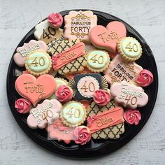 a black plate topped with lots of decorated cookies