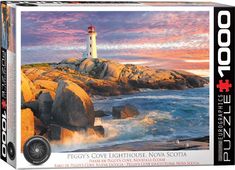 a jigsaw puzzle box with a lighthouse on the rocks in front of water