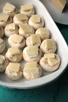 a white dish filled with mushrooms covered in cheese