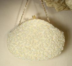 I am SO happy to be offering this beyond beautiful vintage collectible high-end designer "Richere by WALBORG" Art Deco hand beaded warm ivory sequins and white bead gold flapper purse with rhinestone detail perfect for the Bride. I can't tell you how much I adore the design of this purse!  This bag is in near PRISTINE vintage condition. If you've ever seen one of these Walborg purses in person you know that photos are not doing it justice or capturing the attention to detail adequately.  It is completely covered with closely hand sewn ivory sequins and white seed beads in a gorgeous vine pattern.  The beadwork is done over ivory statiny fabric and the design is the same front and back. The purse closes with a rhinestone adorned kiss clasp. Bag measures 8 inches wide and is 6 inches high no White Pearl Embellished Evening Bag, Vintage Evening Bag With Pearl Embroidery, Gold Bags With Pearl Handle, Rectangular Shape, Gold Flapper, Glamorous Pearl-embellished Evening Bag, Vintage White Beaded Clutch, Vintage Glam Wedding, Bridal Bag, Old Hollywood Glam