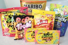 several bags of candy sitting on top of a white table next to eachother