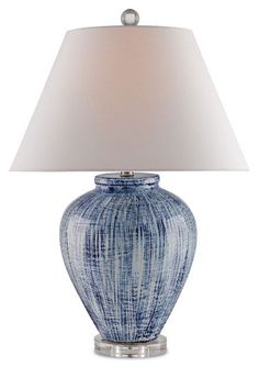 a blue and white lamp with a shade on the top is sitting in front of a white background