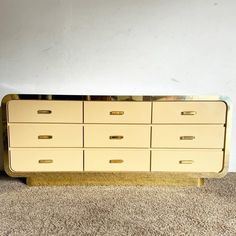 a yellow dresser sitting on top of a carpeted floor next to a white wall