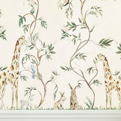 two giraffes are standing next to each other in front of a wall mural