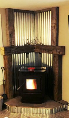 a wood burning stove in a living room next to a wall with metal slats