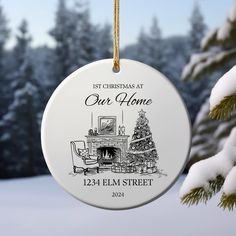 a personalized christmas ornament hanging from a tree in front of snow covered trees