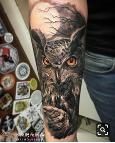 an owl with orange eyes is on the arm