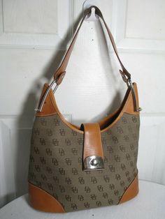 DOONEY & BOURKE  BROWN monogram LOGO  WITH cognac LEATHER  shoulder handBAG NO ORIGINAL RECEIPT, NO BOX, NO DUST BAG     BRAND: DOONEY & BOURKE STYLE: SHOULDER HANDBAG COLOR: BROWN MATERIAL:  LEATHER/CAVAS LINING: FABRIC SIZE:  MEDIUM 12" W x 11" H x 4½" D CLOSURE: CLASP  1 INTERIOR ZIPPERED POCKET     APPROXIMATE MEASUREMENTS:   BAG DEPTH: APPROXIMATELY 4½" BAG LENGTH: APPROXIMATELY 12" BAG HEIGHT: APPROXIMATELY 11" HAND STRAP DROP: APPROXIMATELY 9" CONDITION: PRE-OWNED in great condition; show Leather Shoulder Handbags, Hand Strap, Shoulder Handbag, Bag Brand, Monogram Logo, Lining Fabric, Designer Bags, Dooney Bourke, Shoulder Handbags