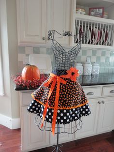 a dress on a mannequin in a kitchen decorated with polka dots and pumpkins