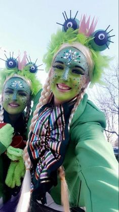 two people with their faces painted like monster heads and green hair are posing for the camera