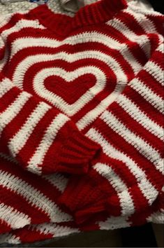 a red and white knitted sweater with a heart on it