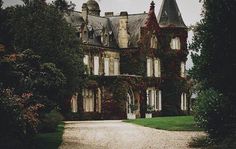 an old house with ivy growing all over it's walls and windows on the front