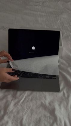 a person is typing on the keyboard of an apple laptop