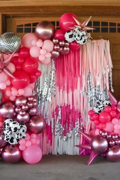 balloons, streamers and other decorations are arranged on the floor in front of a garage door