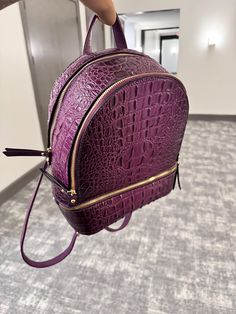 **Purple Crocodile Backpack** Elevate your style with this vibrant purple crocodile backpack, perfect for adventurers and trendsetters alike. Crafted from durable, eco-friendly materials, this eye-catching bag features a textured crocodile pattern that adds a touch of elegance to your everyday look. With spacious compartments and adjustable straps, it's designed for comfort and functionality, making it ideal for school, work, or weekend outings. Whether you're running errands or heading to a concert, this unique backpack will make a bold statement. Stand out from the crowd and carry your essentials in style! Elegant Crocodile Pattern Bags, Luxury Elegant Satchel With Crocodile Pattern, Elegant Red Crocodile Pattern Satchel, High-end Crocodile Pattern Travel Bags, High-end Leather Bag With Crocodile Pattern, Unique Backpacks, Patterned Backpack, Running Errands, Trend Setter