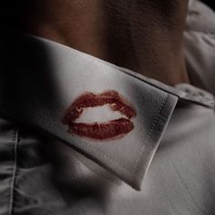 a close up of a person wearing a neck tie with a lipstick imprint on it