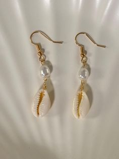 - Gold plated ✨ - Lead and nickel free 🤍 - Real cowrie seashell 🐚 - Each seashell is unique and straight from the ocean/beach 🏝️ - Please note that sometimes seashells have impurities -- they are imperfectly perfect 💖 Cheap Beige Earrings For Beach, Cheap Shell Drop Earrings, Beach Cowrie Shell-shaped Earrings, Cowrie Shell Earrings For Beach, Cowrie Shell Beach Earrings, Beach Shell Earrings Made Of Cowrie, Beach-style Cowrie Shell Earrings, Dangle Shell Earrings With Pearl Drop, Bohemian Beach Shell Earrings For Pierced Ears