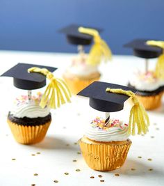 graduation cupcakes with white frosting and gold tassels